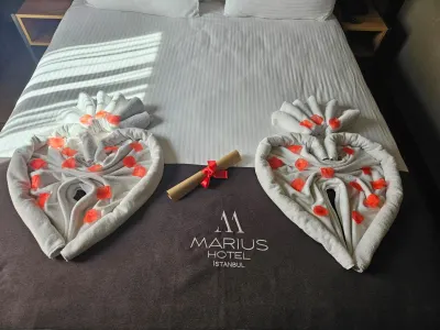 Towel hearts on a bed with the Hotel Marius runner, prepared for a special occasion
