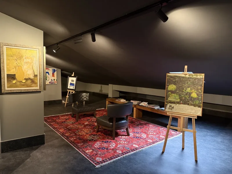 Marius rooftop art gallery — paintings on the columns and the seating area under the sloping roof