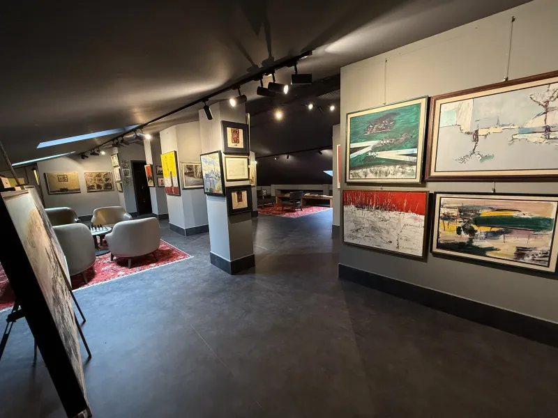 Marius rooftop art gallery — paintings on the columns and the seating area under the sloping roof