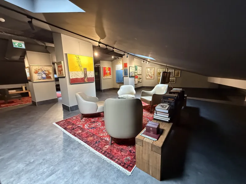 Marius rooftop art gallery — paintings on the columns and the seating area under the sloping roof