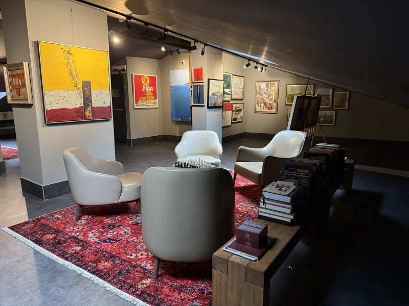 Marius rooftop art gallery — paintings on the columns and the seating area under the sloping roof