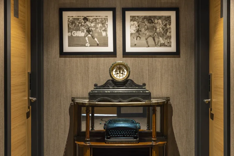 Una macchina da scrivere d'epoca e un orologio da camino su una consolle nel corridoio dell'Hotel Marius