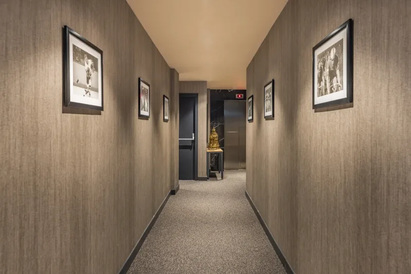 Un tranquillo corridoio con moquette che porta alle camere dell'Hotel Marius
