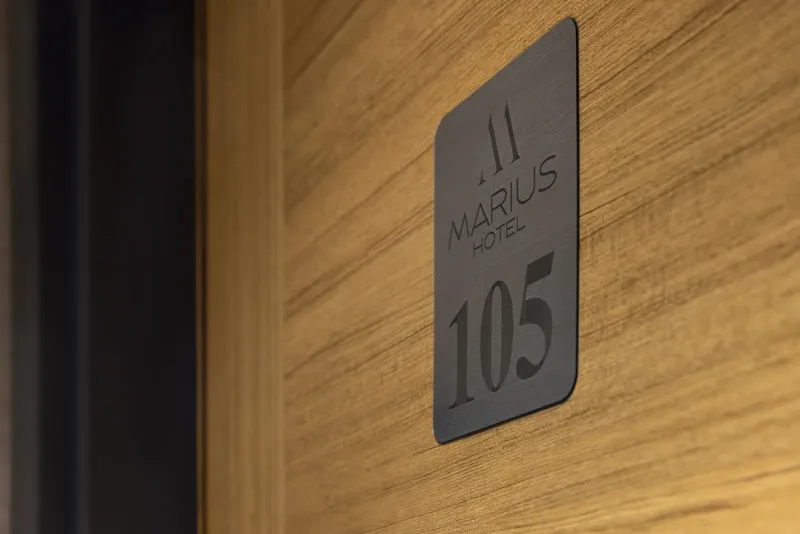La porta in legno della camera 105 con la targa dell'Hotel Marius