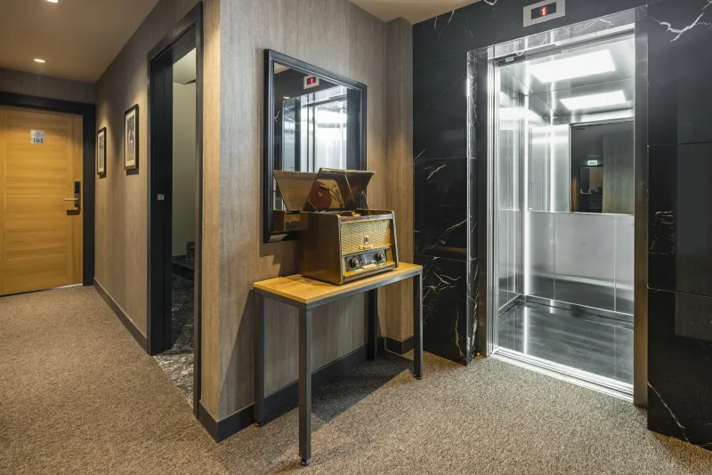 L'ascensore e la consolle con specchio a un piano dell'Hotel Marius