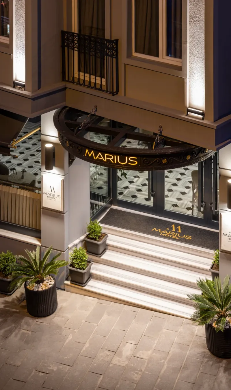 The lit entrance of Hotel Marius after dark
