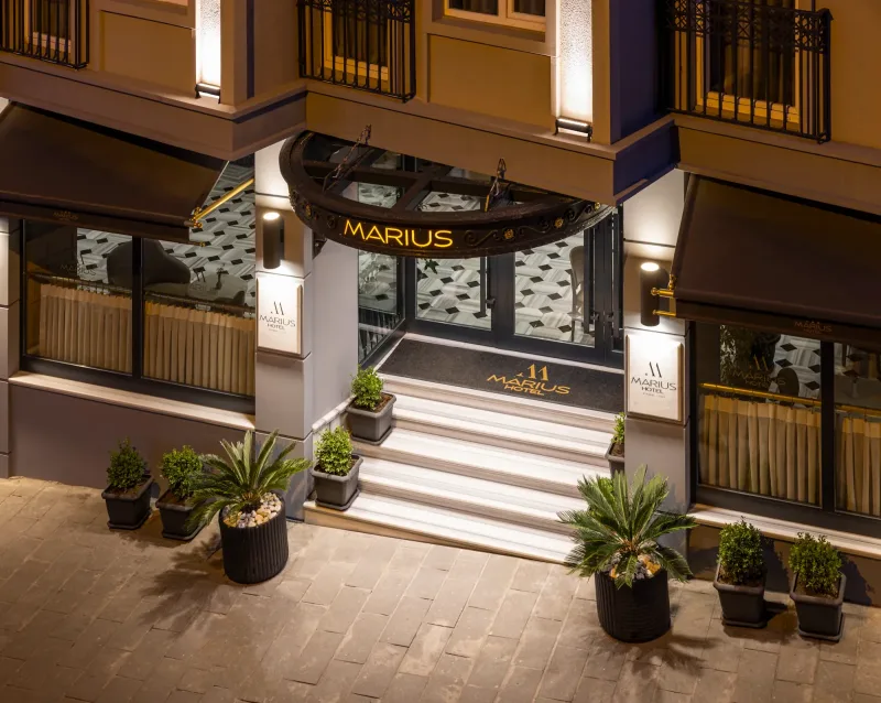 The lit entrance of Hotel Marius after dark