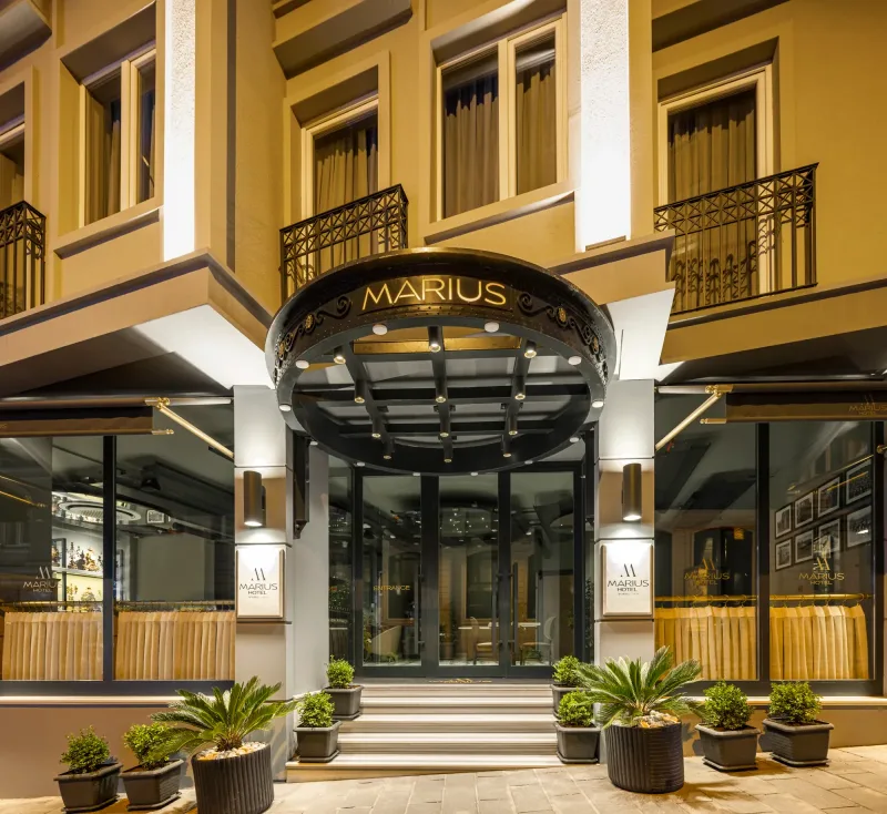 The lit entrance of Hotel Marius after dark