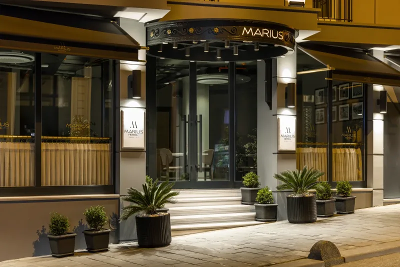 The lit entrance of Hotel Marius after dark