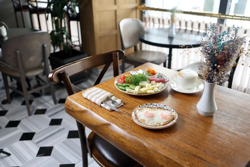 Tavolo della colazione apparecchiato accanto alla finestra all'Hotel Marius