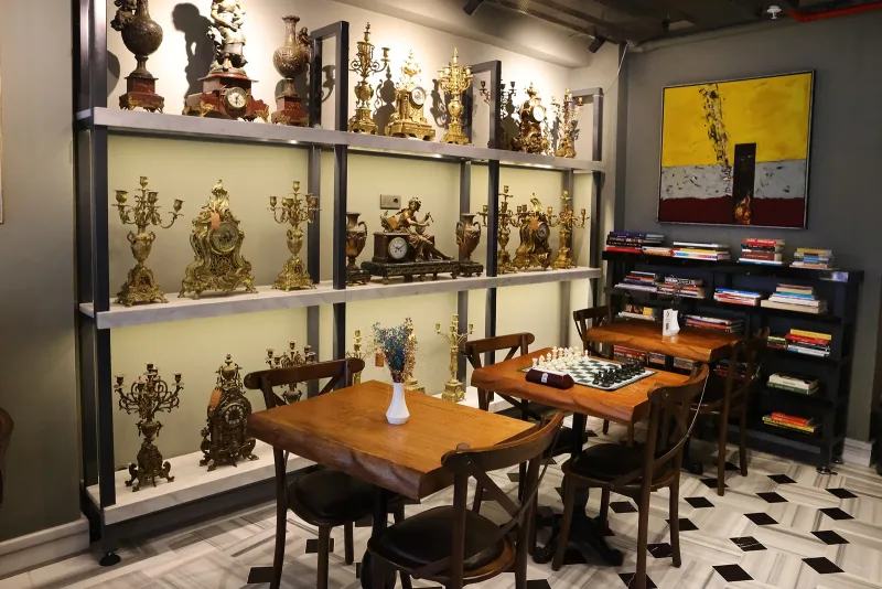 La sala colazioni dell'Hotel Marius, con oggetti in ottone sugli scaffali e pavimento a scacchi