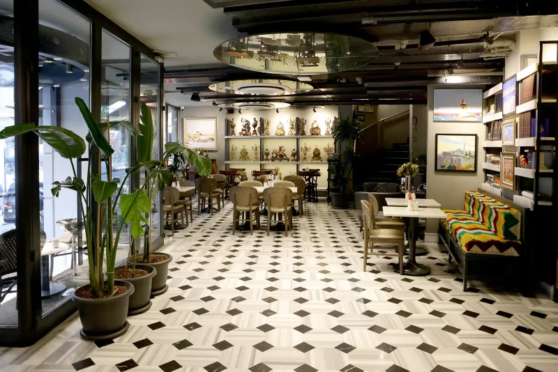La sala colazioni dell'Hotel Marius, con piante e quadri incorniciati alla parete