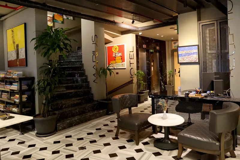 La lounge e il pianerottolo dell'Hotel Marius, con poltrone e tavolo in marmo