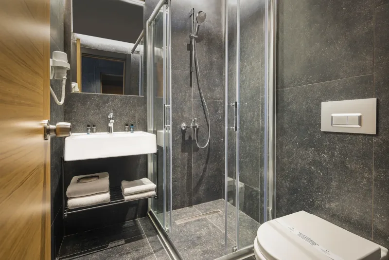 Deluxe Single room at Hotel Marius — single bed, desk by the window and walk-in shower