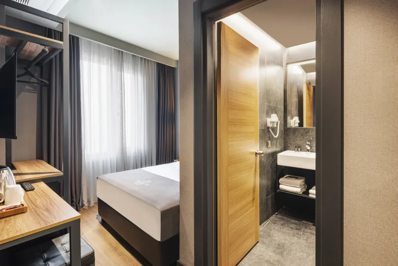 Deluxe Single room at Hotel Marius — single bed, desk by the window and walk-in shower